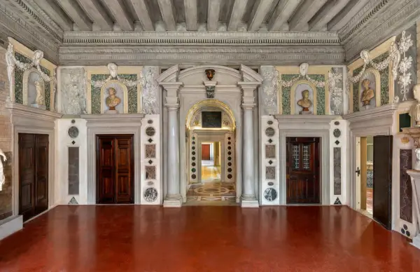 Intérieur du Palazzo Grimani, avec ses portes en bois sombres, ses bustes en marbre et ses décorations murales élaborées.