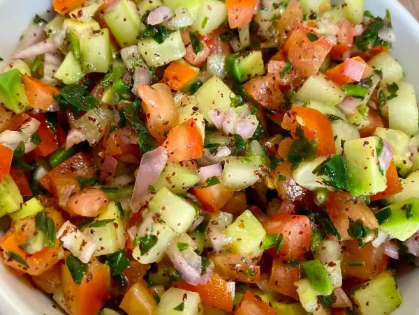 Salade marocaine fraîche et colorée, mélange de tomates, concombres, oignons rouges et persil, assaisonnée d'épices.