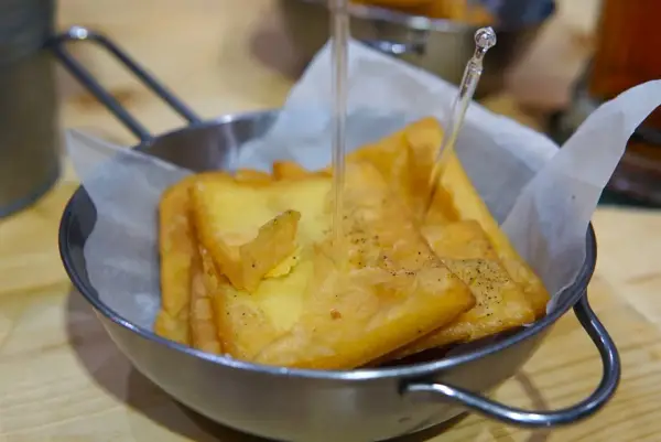Un cestino di pane e panelle dorate, croccanti e appena fritte, pronte per essere gustate.