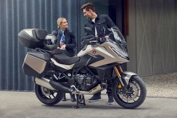 Para zwiedzająca motocykle z automatyczną skrzynią biegów. Nowoczesny design i praktyczne kufry zachęcają do wspólnych podróży.