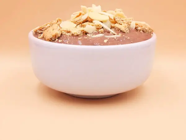 Czekoladowy pudding proteinowy z płatkami migdałów i pokruszonymi ciasteczkami. Czy pudding proteinowy jest zdrowy? To zależy od składników!