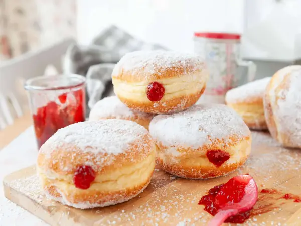 Frisch gebackene Krapfen im Airfryer, mit Puderzucker bestäubt und Marmelade gefüllt. Ein süßer Genuss!
