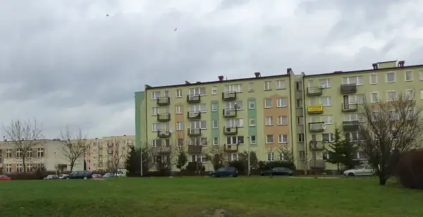 Bloki mieszkalne w Łodzi, z widocznym szyldem "SPRZEDAM". Ceny mieszkań w Łodzi mogą być różne, ale te budynki wyglądają na typowe dla osiedli z lat 70.