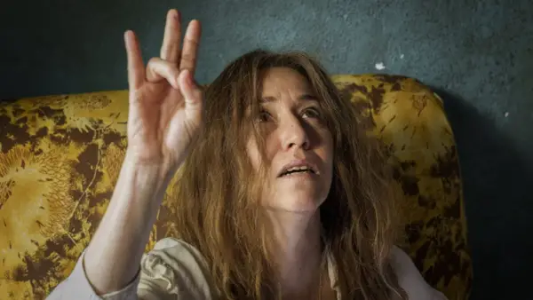 Irene Balmes, con el pelo revuelto, levanta la mano en un gesto místico.