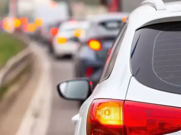 Un coche blanco en un atasco, con sus luces de freno rojas encendidas. ¿Cuántas luces de freno tiene un coche?