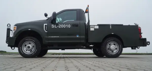 Ciemnozielony Ford F350 z zabudową typu "flatbed" i numerem SL-20010. Solidna maszyna gotowa do pracy.