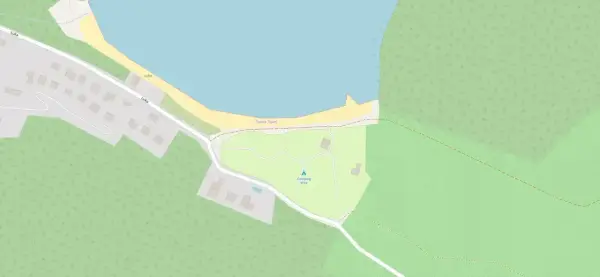 Mapa pokazuje obszar z zabudowaniami, drogami i linią brzegową. Widać tu camping Vrila, otoczony zielenią i blisko morza.