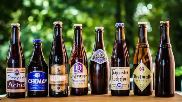 Une sélection de 7 bières trappistes belges alignées : Achel, Chimay, Gregorius, La Trappe, Orval, Rochefort, Westmalle.