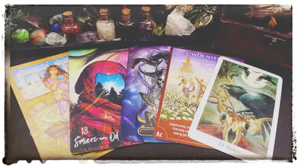 Tarot karta śmierci, numer 13, symbolizuje koniec i nowy początek. Obok niej inne karty i magiczne przedmioty.
