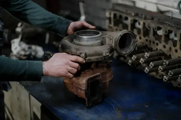 Mechanik sprawdza turbosprężarkę, przygotowując się do jej montażu.
