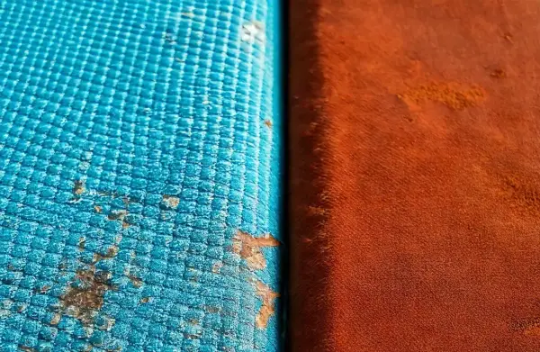 Dettaglio di un test di **salt spray** su due materiali: uno blu con macchie di corrosione, l'altro arancione.