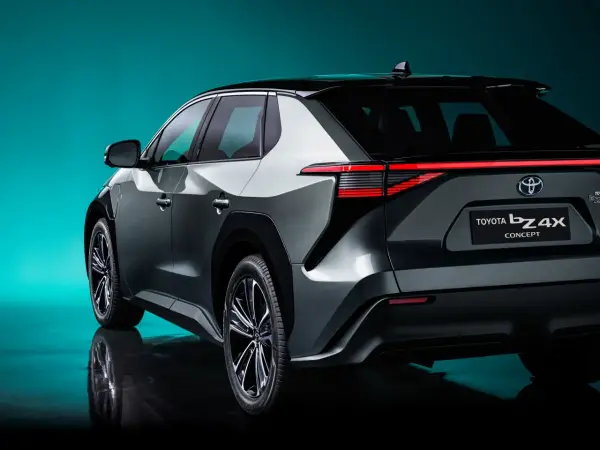 Tył samochodu Toyota bZ4X Concept na tle turkusowego tła.