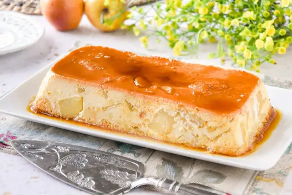 Delicioso pudin de manzana con caramelo líquido, trozos de manzana visibles en su interior.