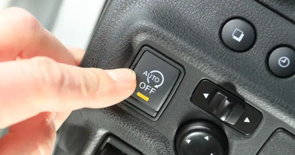 Palec naciska przycisk "AUTO OFF", wyłączając system start-stop.