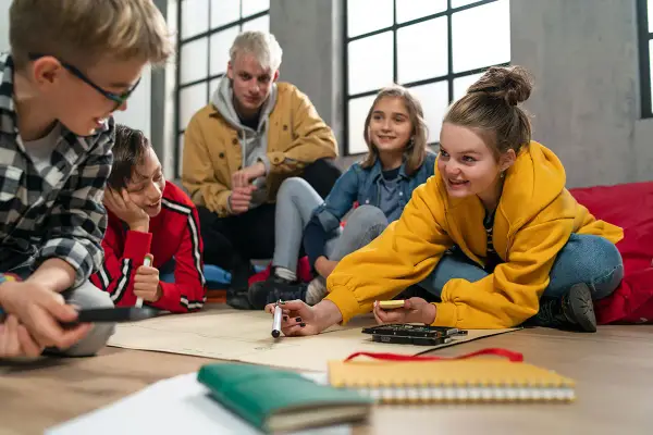 Kinder und Jugendliche arbeiten begeistert an einem Projekt. Der **Präsenzunterricht** fördert Kreativität und Teamwork.