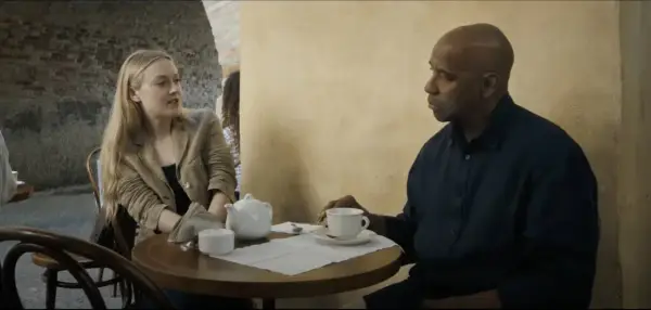Denzel Washington i Dakota Fanning rozmawiają przy stoliku w kawiarni. To scena z filmu "Bez litości obsada".