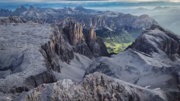 Viste mozzafiato dalle cime rocciose del Piz Boè, con un verde villaggio incastonato tra le valli.