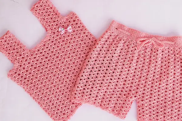 Conjunto de top y pantalón corto de crochet rosa para niña. El pantalón corto tiene un cordón para ajustar.