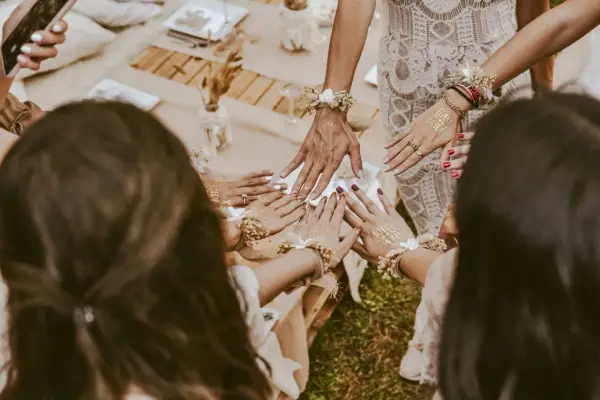 Dłonie ozdobione tatuażami "Team Bride" i bransoletkami z kwiatów. Wspaniałe panieńskie pomysły na celebrację!