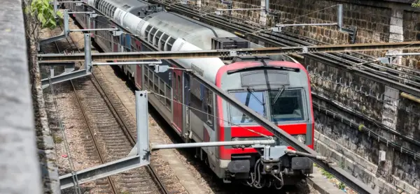 Pociąg RER A w Paryżu na torach, z widocznymi elementami infrastruktury kolejowej.