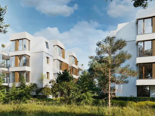 Nowoczesna sopocka architektura, białe budynki z drewnianymi elementami i dużymi oknami, otoczone zielenią.
