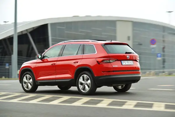 Czerwona Skoda Kodiaq w ruchu. Wiele pozytywnych skoda kodiaq opinie potwierdza jej wszechstronność.