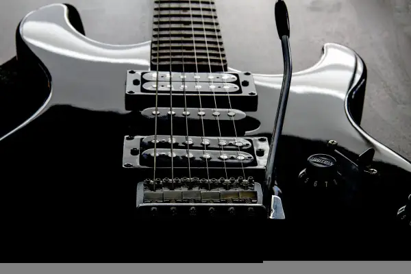 Czarna gitara elektryczna z sześcioma strunami, gotowa do rockowych riffów.