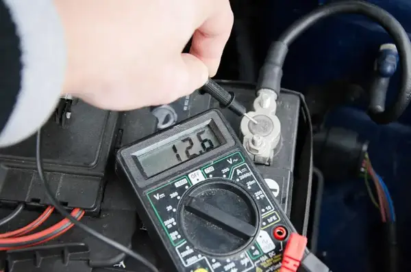 Pomiar napięcia akumulatora multimetrem. Wynik 12.6V wskazuje na dobry stan.