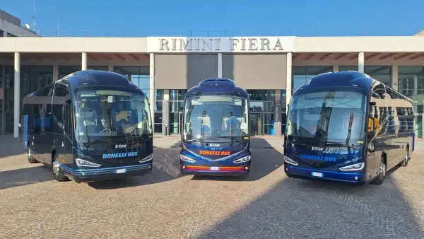 Tre bus Bonelli Bus blu scuro pronti per il viaggio da Rimini a San Marino, con la scritta "Rimini Fiera" sullo sfondo.