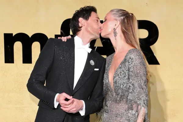 Adrien Brody i jego żona, Georgina Chapman, całują się na ściance.