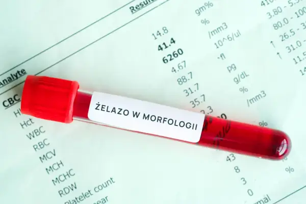 Czerwona probówka z krwią na tle wyników badań laboratoryjnych. Etykieta na probówce informuje o badaniu "ŻELAZO W MORFOLOGII".