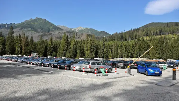 Parking pełen aut pod Tatrami, gotowych na wycieczkę nad Morskie Oko.