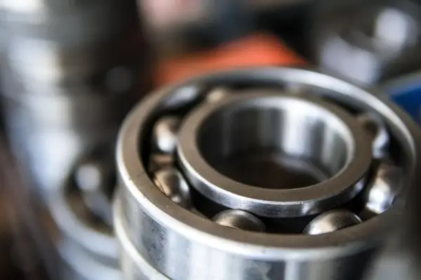 Zbliżenie na metalowe łożysko kulkowe z widocznymi kulkami.