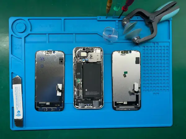 Tres iPhones desarmados en una alfombrilla azul. El led integrado se puede cambiar, facilitando la reparación.