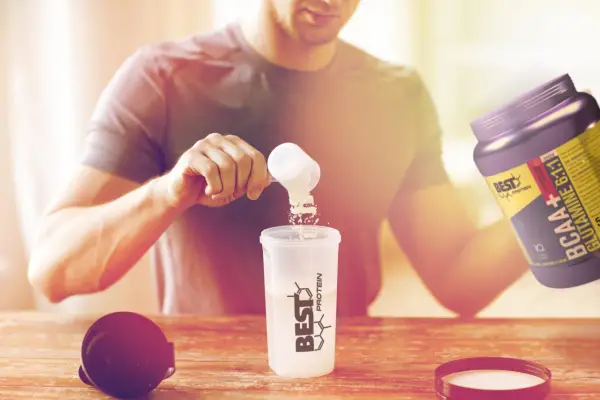 Hombre preparando su batido post-entreno. Es bueno tomar BCAA para la recuperación muscular.