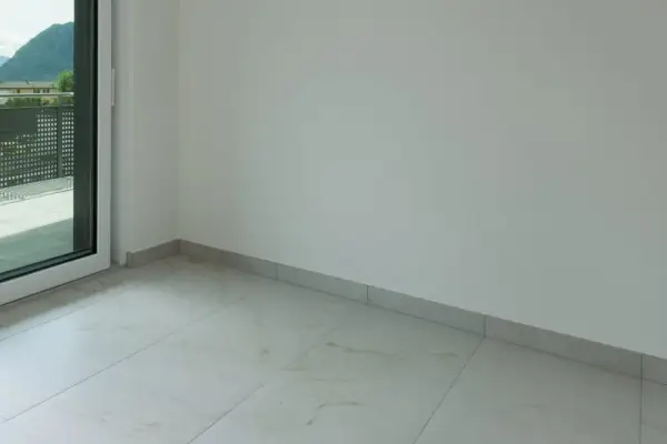 Plinthe grise discrète pour carrelage imitation marbre. Un choix idéal pour une finition propre et moderne.
