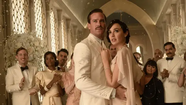 Śmierć na Nilu obsada: Armie Hammer i Gal Gadot w eleganckich strojach, otoczeni przez innych aktorów, podczas uroczystości.