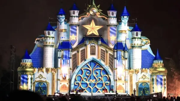 Castillo iluminado con estrellas doradas y detalles azules, evocando la magia de las **parques mágicas navidades**.