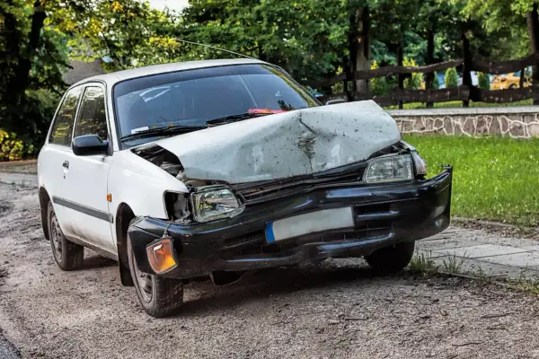 Uszkodzony biały samochód po wypadku. Zastanawiasz się ufg co to? To ubezpieczeniowy fundusz gwarancyjny, który pomaga w takich sytuacjach.