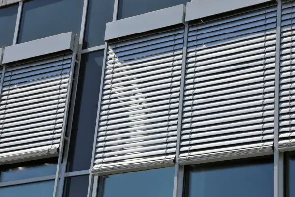 Volets roulants modernes sur une façade de bâtiment. L'image suggère la durabilité et la longévité du moteur de volet roulant.