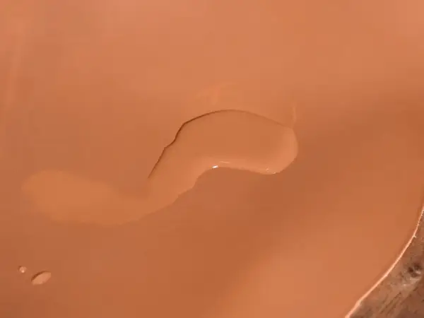 Une tache d'eau sur cuir non traité, créant une légère décoloration.