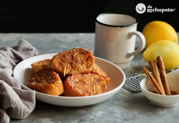 Torrijas de pan doradas y crujientes, espolvoreadas con ralladura de limón. Un clásico de las recetas de torrijas de pan, perfecto para disfrutar.