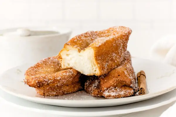 Torrijas doradas y crujientes, espolvoreadas con azúcar y canela. ¡La mejor receta de torrijas para disfrutar!