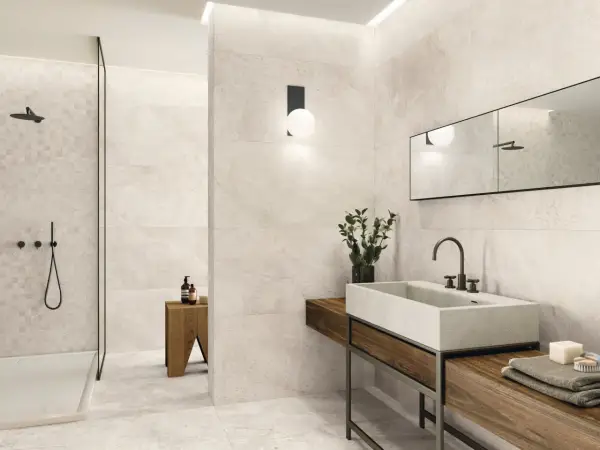 Salle de bain moderne avec carrelage 60x120 pose décalée, douche vitrée, vasque en pierre et meuble en bois.