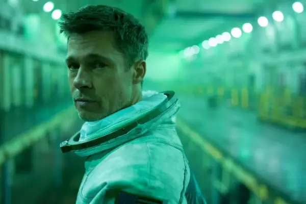 Brad Pitt w skafandrze kosmicznym w filmie Ad Astra, w zielonej poświacie tunelu.