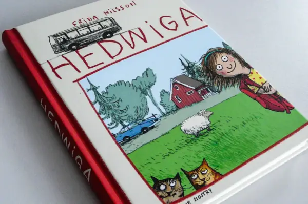Okładka książki "Hedwiga" Fridy Nilsson, idealna dla 7 latka. Zabawna ilustracja z dziewczynką, owcą, kotami i autobusem.