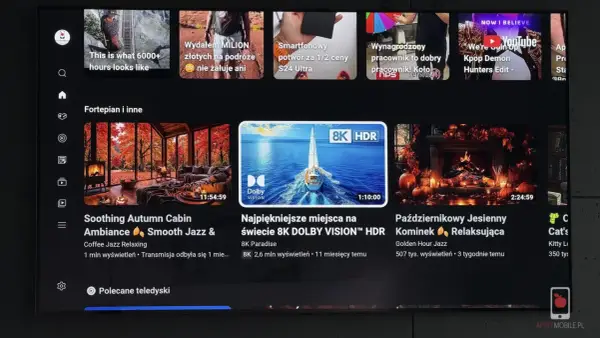 Ekran telewizora z interfejsem YouTube. Widać reklamy, w tym "Kpop Demon Hunters Edit", oraz filmy relaksacyjne, np. "Soothing Autumn Cabin". Użycie youtube adblock pozwala na oglądanie bez przerw.