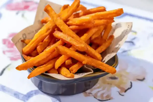 Frites de patate douce dorées et croustillantes, parfaites pour une recette facile et savoureuse.