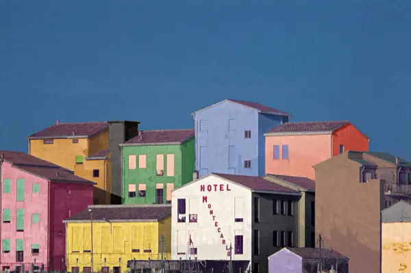 Case colorate e un cielo blu intenso, un paesaggio che ricorda le opere di Franco Fontana.