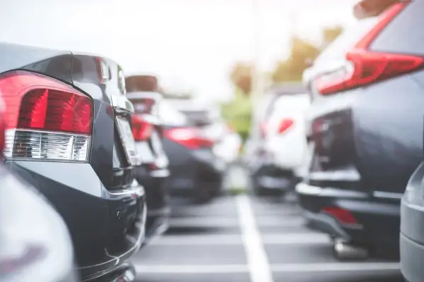 Rzędy samochodów na parkingu. Widać tylne światła i zderzaki. Czy to nowy oc?